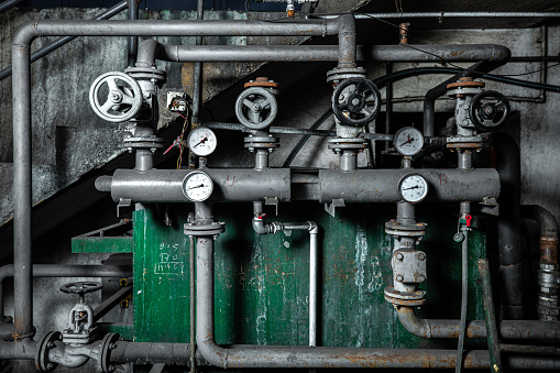 Close up of industrial pipes with valves and preasure gauge