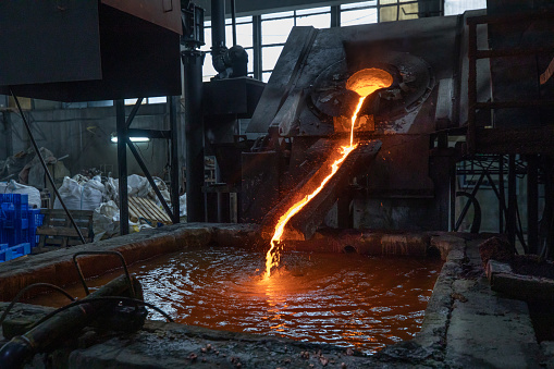 Industrial copper casting in factory, molten copper  flowing into water for cooling