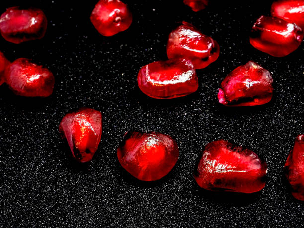 istock red grains of ripe pomegranate on a black background, macro 1288643480