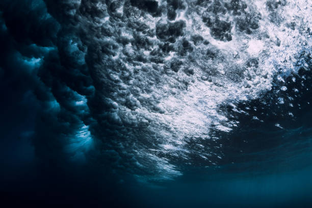 istock Underwater ocean wave with foam and bubbles. Transparent water and breaking wave 1288643604