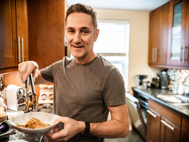 istock Mature man serving lunch in kitchen 1288643936