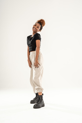 Cheerful young african american woman girl smiling and posing in comfortable casual clothes. People sincere emotions lifestyle concept. A lot of copy space on a white studio background.