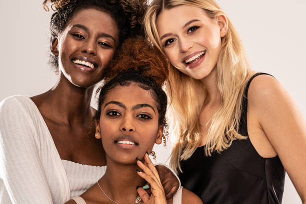 Three attractive young multiethnic women looking at camera, smiling. Close up beauty portrait of three attractive young multiethnic women looking at camera, smiling. Group of happy female multiracial friends. Studio shot. multiculturalism photos stock pictures, royalty-free photos & images