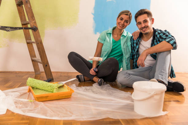 istock Happy young couple taking a break from painting and smiling at camera 1288650010