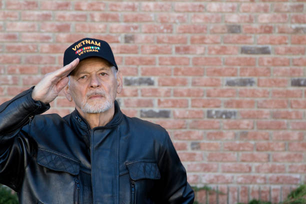istock Vietnam Veteran standing outdoors saluting looking at camera 1288652257