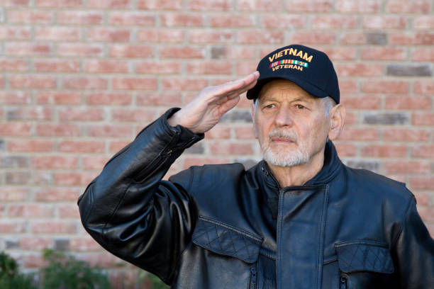 istock Vietnam Veteran standing outdoors saluting looking away 1288652295