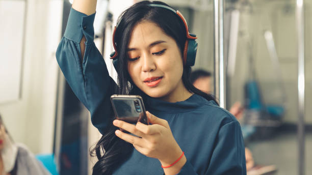 istock Young woman using mobile phone on public train 1288652701