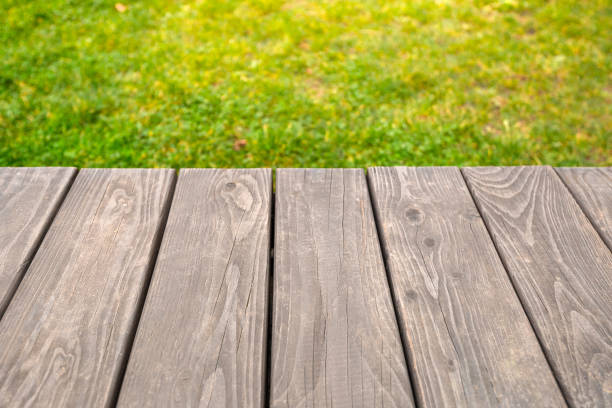 istock Empty wooden table on bright green abstract blurred background, for product display montage 1288652720