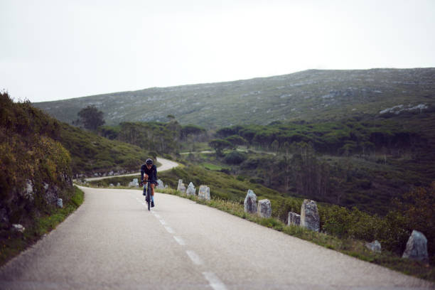 istock Professional cyclist riding uphill a mountain 1288654017