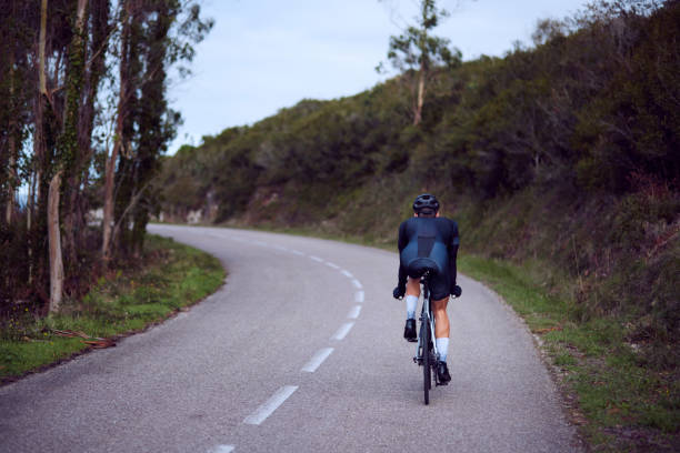 istock Active professional cyclist going uphill on a forest road 1288654223