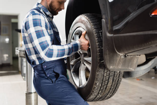 istock cropped view of young technician fixing wheel on car in workshop 1288655535