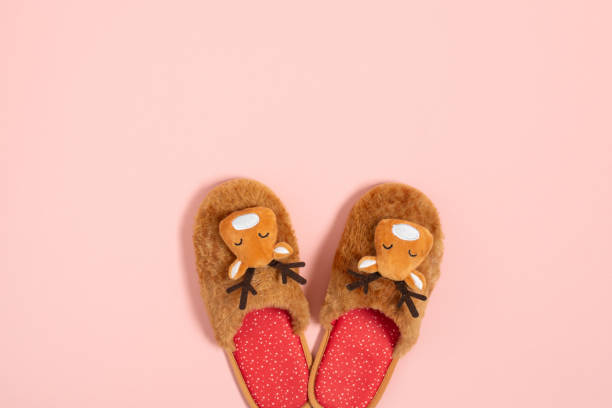 istock Cozy Christmas slippers on pink background top view. 1288655647