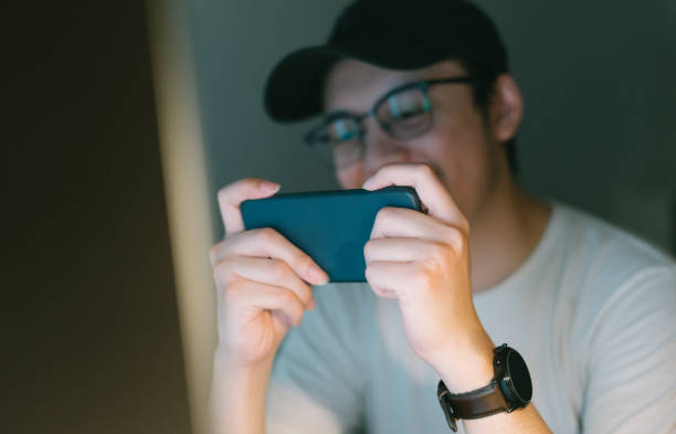 istock asian young man excited playing mobile game on his smartphone 1288661860