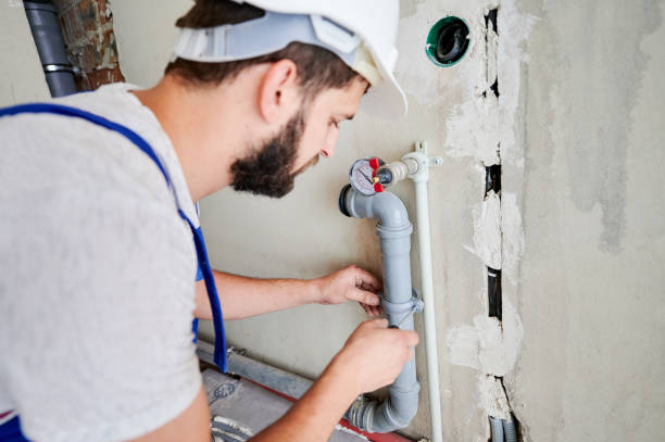 istock Male plumber screwing clamp on pipe with screwdriver. 1288662644