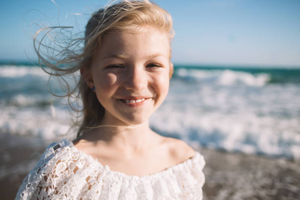 istock Cute little girl smiling under bright sunlight 1288663333