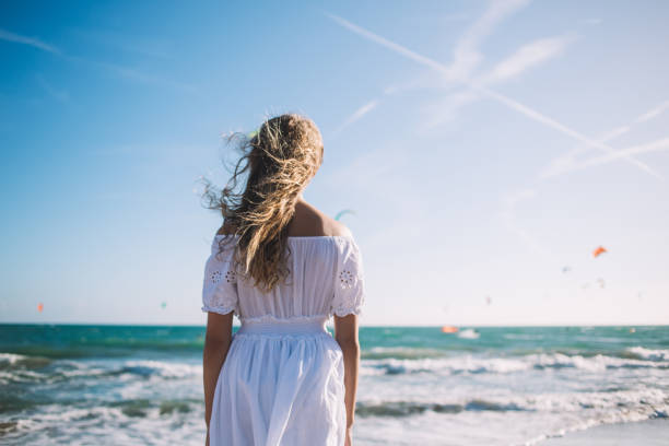 istock Faceless teenager looking at sea on beach 1288663335