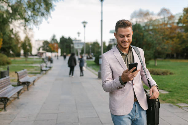 istock Young businessman walking and sending text message 1288663451