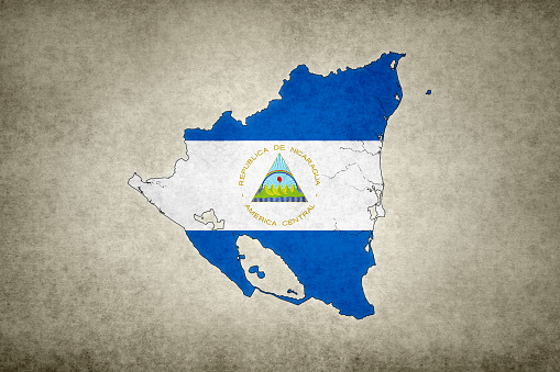 Grunge map of Nicaragua with its flag printed within its border on an old paper.