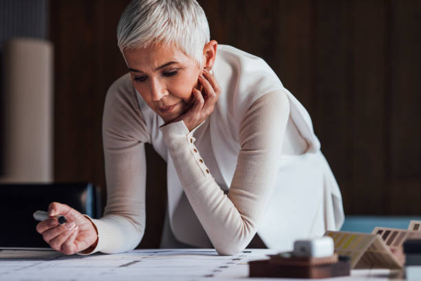 istock Stylish Senior Female Architect Designing a Plan for her Latest Project 1288664649