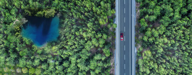 vista aerea di un piccolo stagno nella foresta e nell'autostrada - asphalt beauty in nature nature scenics foto e immagini stock