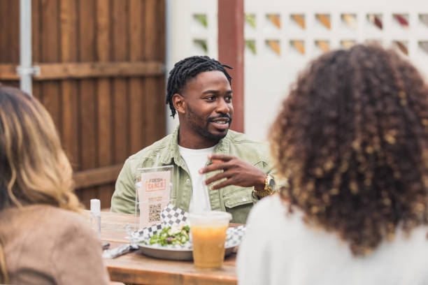 istock Young man enjoys lunch with friends or colleagues 1288665694