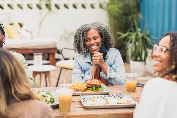 istock Woman enjoys lunch with friends 1288665698