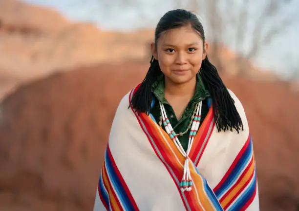 Happy North american indigenous  teen portrait in front of a Navajo hogan