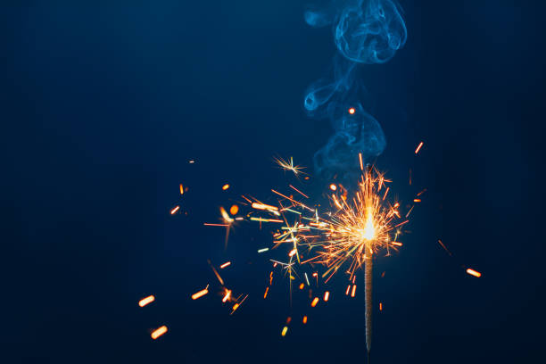 istock shiny fire sparkler on dark blue background 1288666133