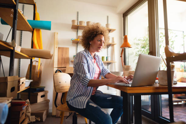 istock Small business owner using laptop in her pottery workshop 1288666982