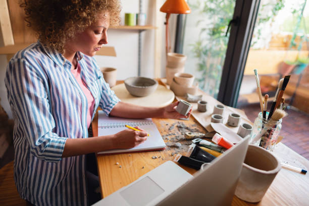 istock Woman artisan working on a new ideas in a pottery creative studio 1288666991