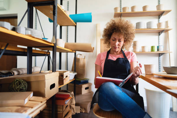 istock Artisan with a planner book in her small business pottery studio 1288667004