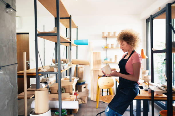 istock Middle age female potter holding  a pot in her pottery studio 1288667032