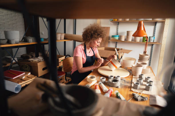 istock Middle age woman painting pot in her creative pottery studio 1288667113