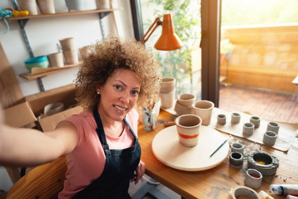 istock Craftswoman taking a selfie in her small business pottery studio 1288667157