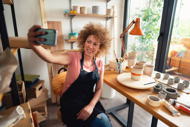 istock Female potter taking a selfie in her creative pottery studio 1288667161