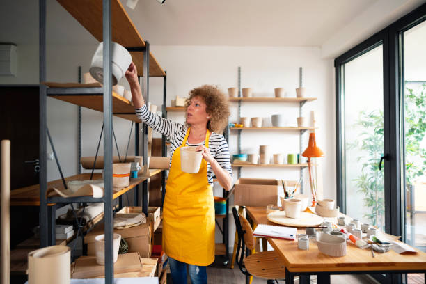 istock Woman arranging concrete pots on a shelf 1288667300