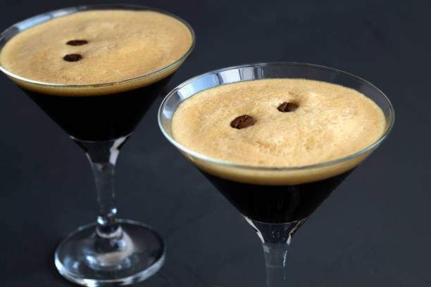 istock Espresso Martini cocktail garnished with coffee beans on dark table. Two Martini glasses on a black background. alcohol drinks. copy space. 1288667433