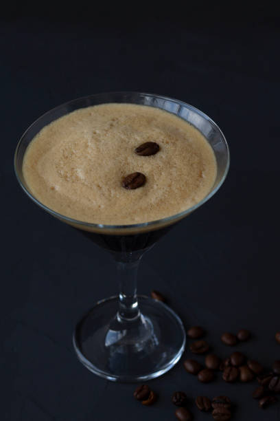 istock Espresso Martini cocktail garnished with coffee beans on dark table. Martini glass on a black background. alcohol drinks. copy space. vertical. top view 1288667461