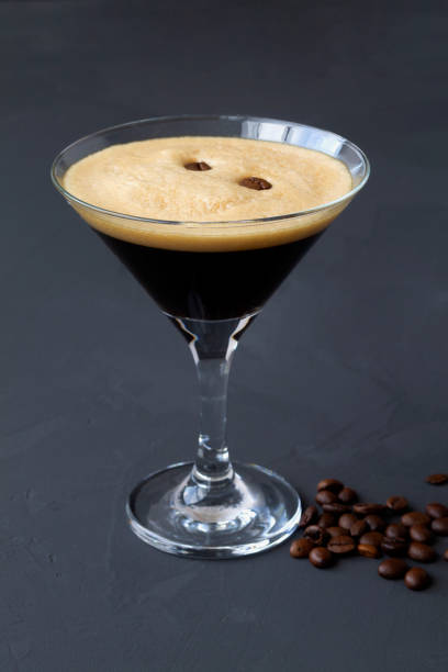 istock Espresso Martini cocktail garnished with coffee beans on dark table. Martini glass on a black background. alcohol drinks. copy space. vertical 1288667484