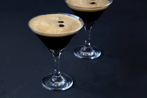 istock Espresso Martini cocktails garnished with coffee beans on table. Two martini glasses on a black background. alcohol drinks 1288667496