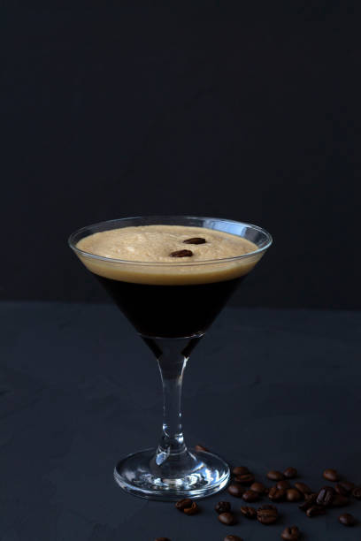 istock Espresso Martini cocktail garnished with coffee beans on dark table. Martini glass on a black background. alcohol drinks. copy space. vertical 1288667508
