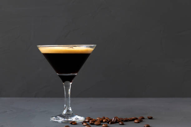 istock Espresso Martini cocktail garnished with coffee beans on table. Martini glass with brown coffee beans on a black background. alcohol drinks. copy space 1288667518