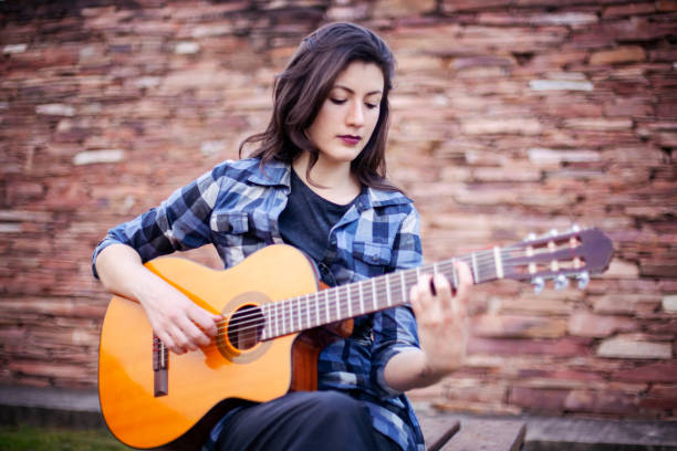 istock Singer young woman playing guitar 1288669183