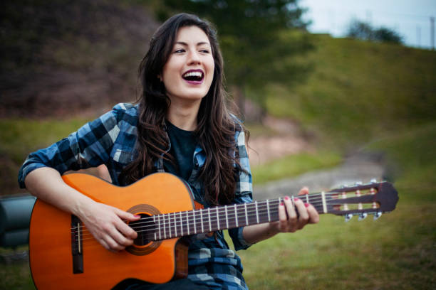 istock Singer young woman playing guitar 1288669325