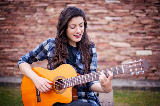 istock Singer young woman playing guitar 1288669852