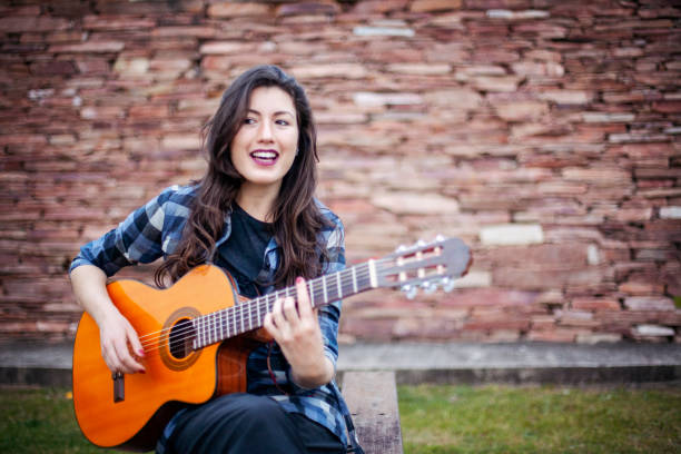 istock Singer young woman playing guitar 1288669862