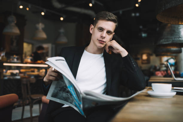 istock Pensive man with newspaper in cafe 1288670774
