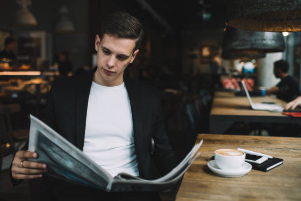 istock Serious businessman reading newspaper in cafe 1288670795