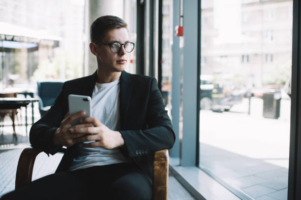 istock Elegant entrepreneur browsing smartphone in cafe 1288670903