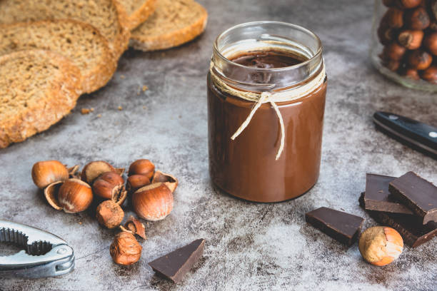 istock Homemade hazelnut chocolate butter, hazelnut, dark chocolate, on black stone background. 1288673387